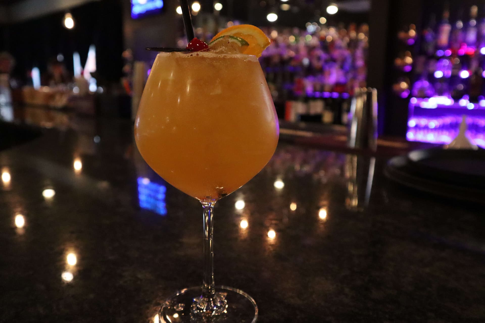 Orange cocktail with cherry and orange garnish at The Manhattan bar