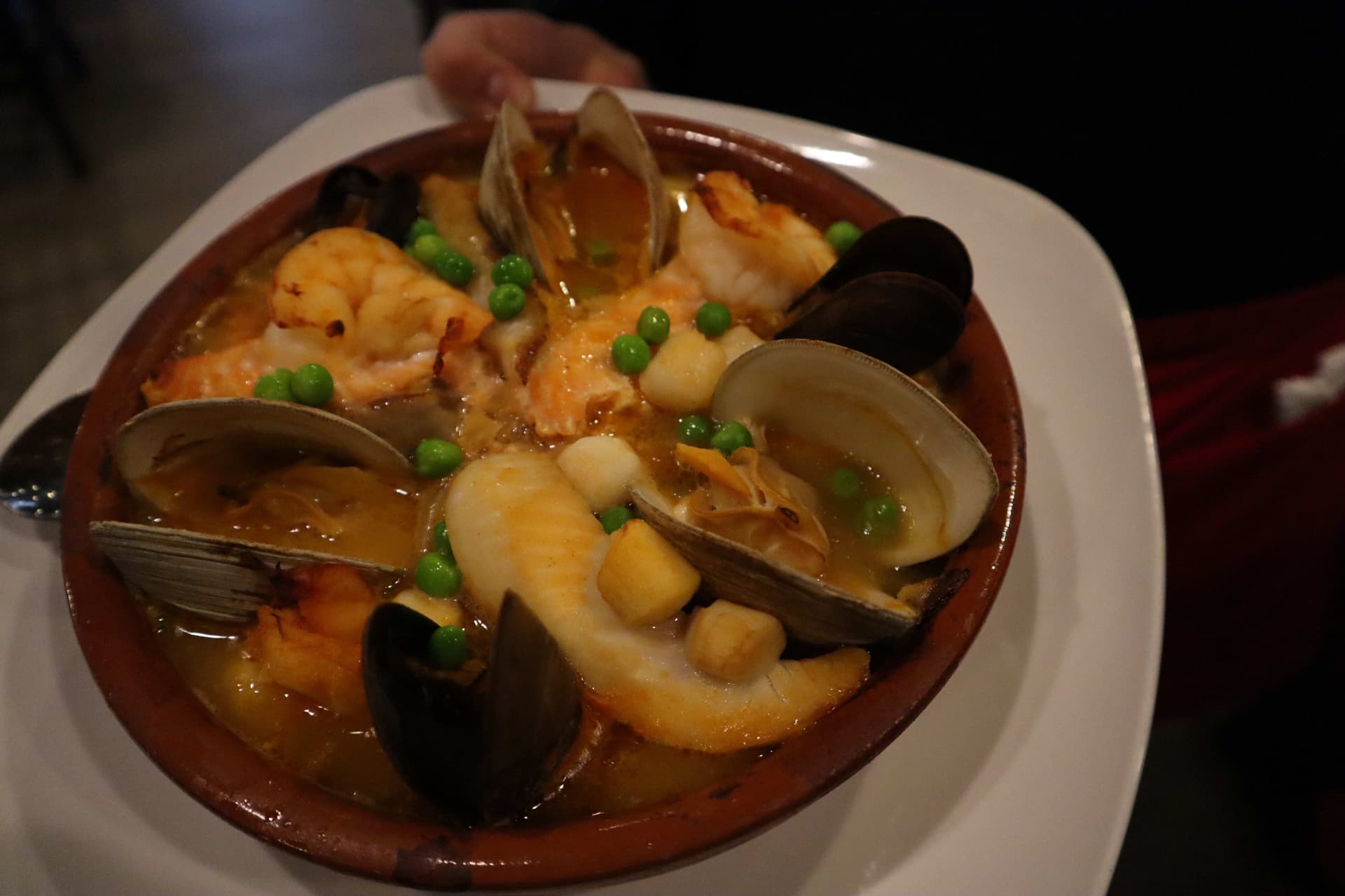 Traditional Spanish seafood paella in terracotta cazuela by Chef Fabian