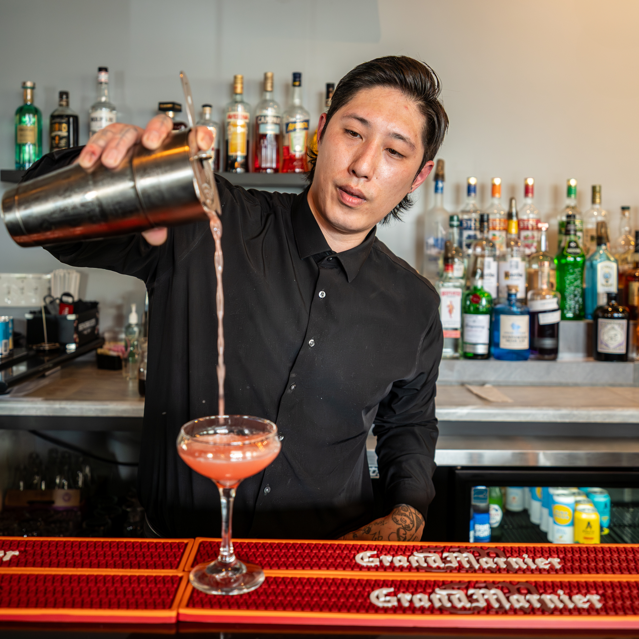Bartender pouring a craft cocktail at The Manhattan bar
