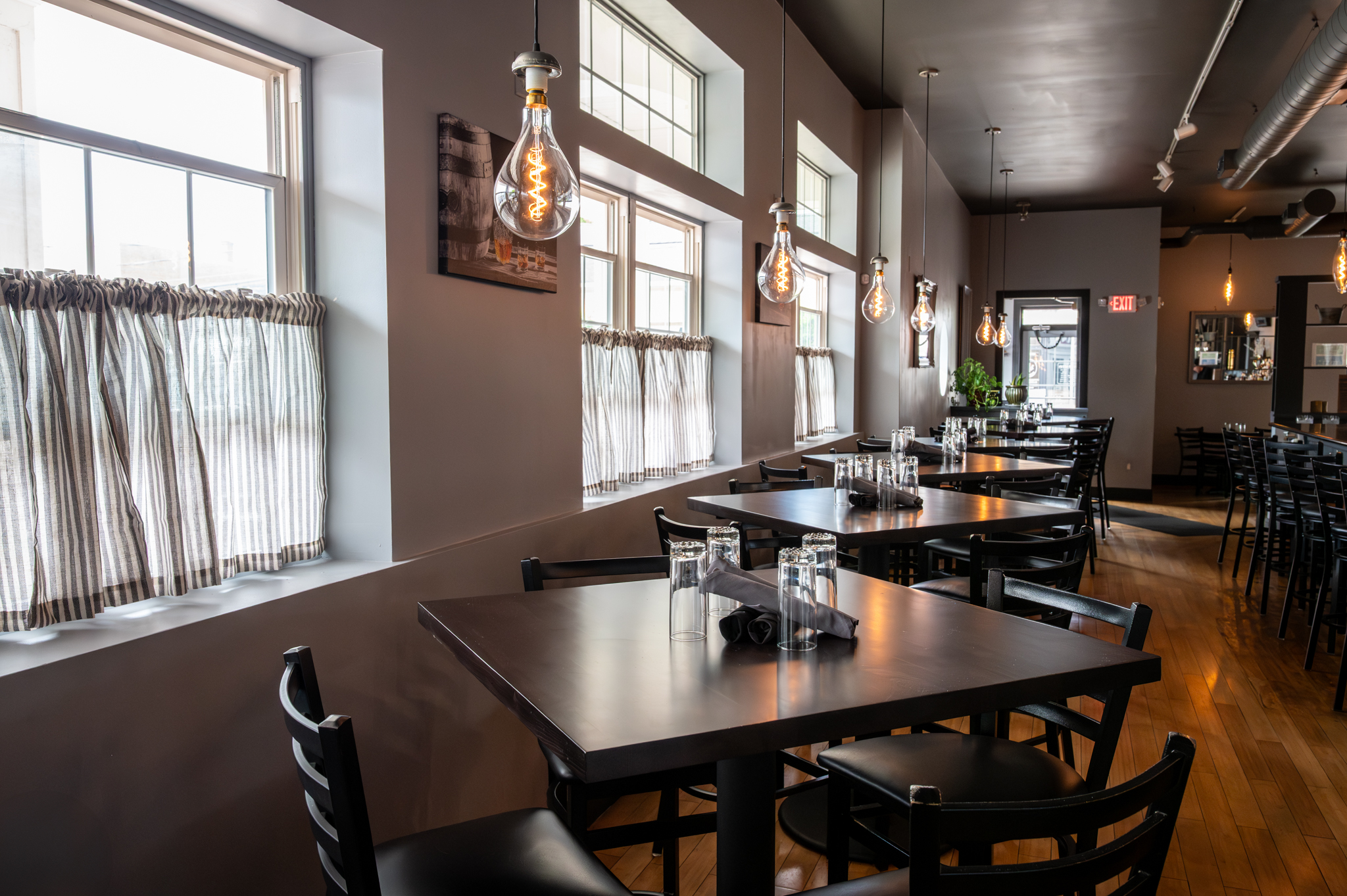The Manhattan dining room with pendant lights and set tables